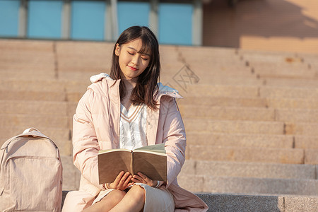 粉色台阶在校园台阶上看书的大学生背景
