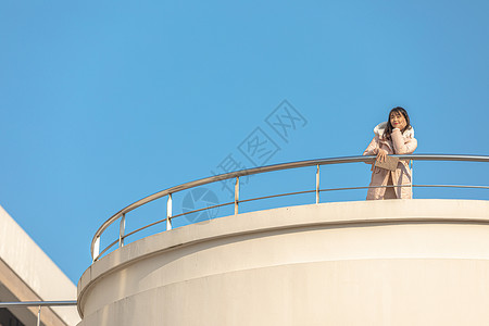 趴在天台栏杆前的甜美女孩背景