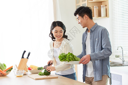 年轻夫妻在厨房一起备菜高清图片