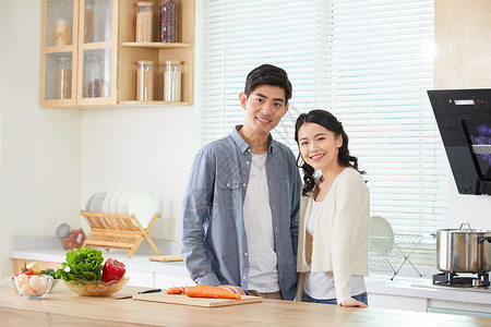 年轻夫妻在厨房一起做菜图片