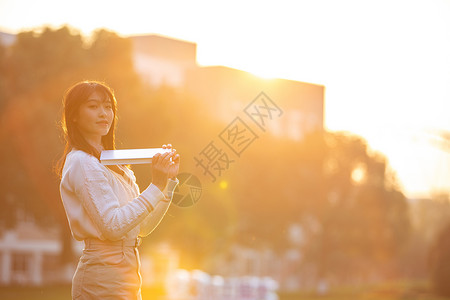 夕阳下活泼的女大学生高清图片