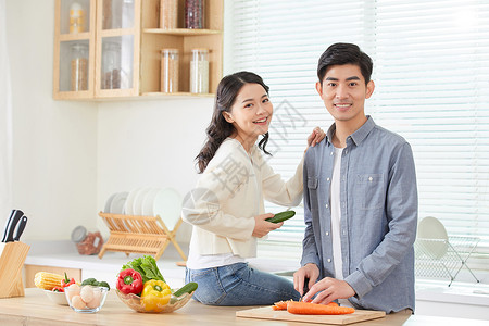 年轻夫妻在厨房甜蜜互动高清图片