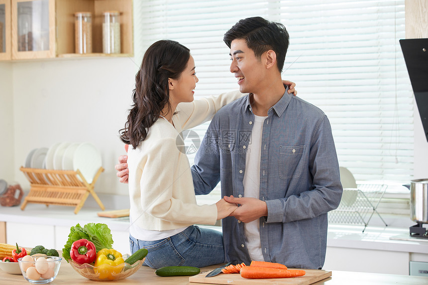 年轻夫妻在厨房甜蜜互动图片