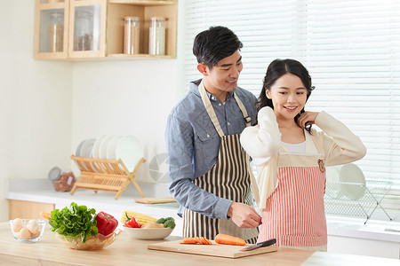 系围裙的人年轻男士给妻子系戴围裙背景