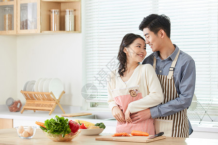 情侣在厨房拥抱互动年轻夫妻在厨房甜蜜互动背景