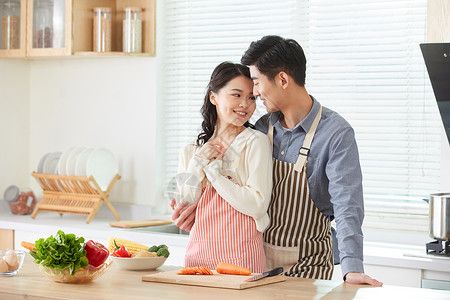 年轻夫妻在厨房一起备菜图片