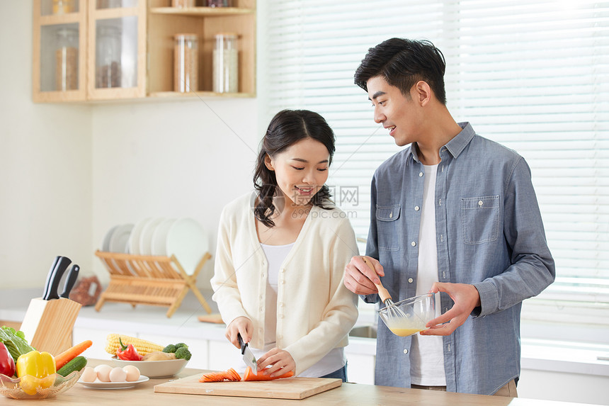 年轻夫妻在厨房甜蜜互动图片