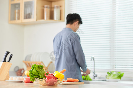 年轻男士在厨房洗菜背影背景图片