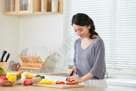 年轻女士在厨房切菜高清图片