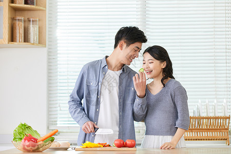 年轻情侣在厨房备菜甜蜜互动图片