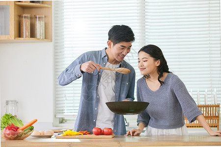 年轻老婆闻丈夫炒菜味道背景图片