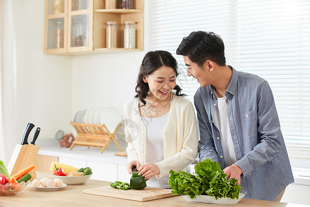 一起烹饪的情侣年轻夫妻在厨房一起备菜背景