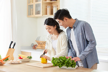 一起烹饪的情侣年轻夫妻在厨房一起备菜背景