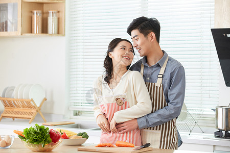 一起烹饪的情侣年轻夫妻在厨房一起备菜背景