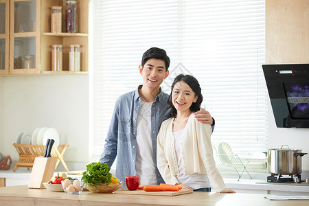 一起烹饪的情侣年轻夫妻在厨房一起备菜背景