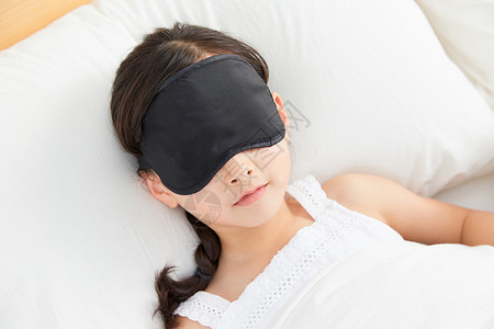 戴眼罩的人小女孩躺在床上戴眼罩睡午觉背景