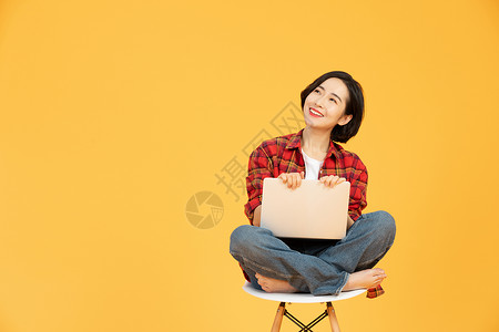 年轻女性坐椅子上网购消费高清图片
