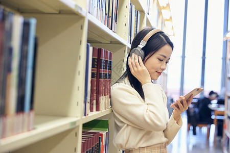 女学生在图书馆听音乐背景图片