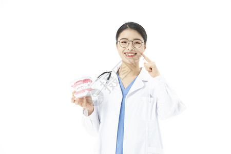 女性牙医拿着假牙讲解牙齿健康背景图片