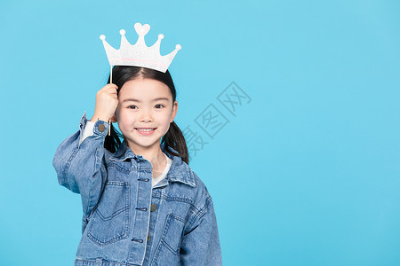 小女孩拿趣味小皇冠拍照图片