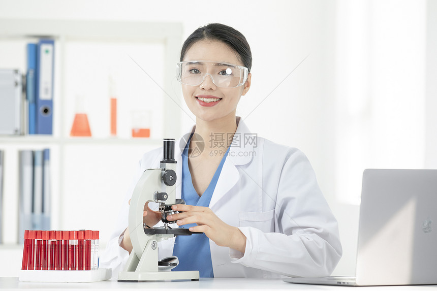 女性医生显微镜观察血液试剂图片