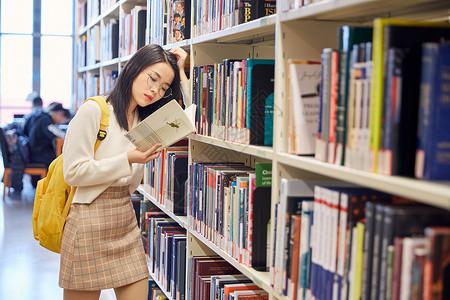 年轻女学生在图书馆看书图片