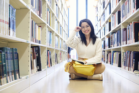 年轻女学生在图书馆看书图片