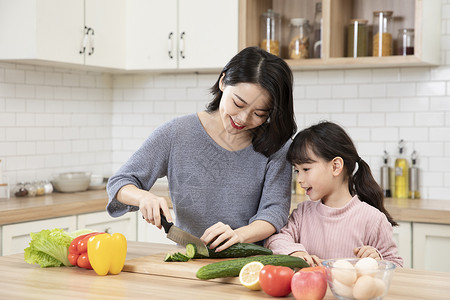女儿和母亲一起看手机居家母女一起厨房做饭背景