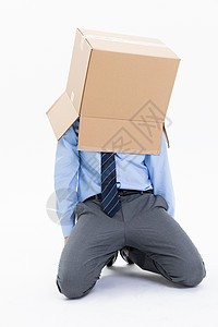 跪在地上的青年男性头上套着纸盒箱图片
