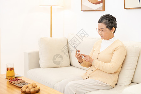 老奶奶坐沙发上玩手机图片