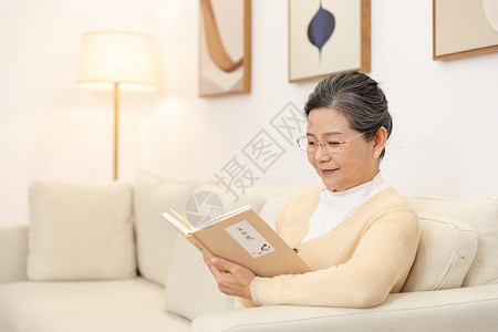 老奶奶坐沙发上看书背景图片