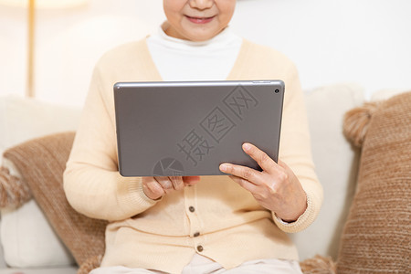 老奶奶拿平板电脑局部特写背景图片