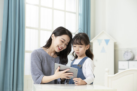 母女上学妈妈和女儿用平板电脑上网课背景
