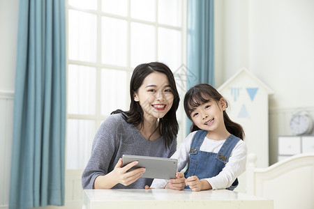 妈妈和女儿用平板电脑上网课高清图片