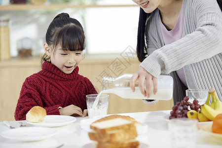 小女孩喝牛奶妈妈给女儿倒牛奶背景