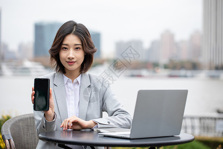 商务职业女性在户外办公展示手机图片
