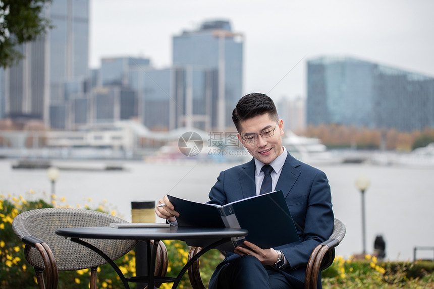 商务男性白领在户外办公看文件图片