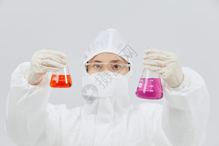 拿试剂瓶穿防护服查看试剂瓶的科研人员背景