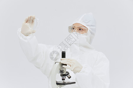 医用显微镜穿防护服科研人员查看培养皿背景