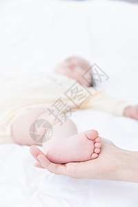 妈妈用手托着婴儿的脚图片