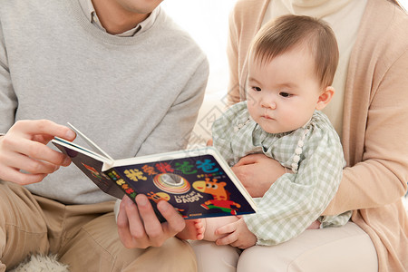 爸爸妈妈给婴儿看书讲故事高清图片