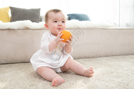婴儿拿着橙子玩耍高清图片