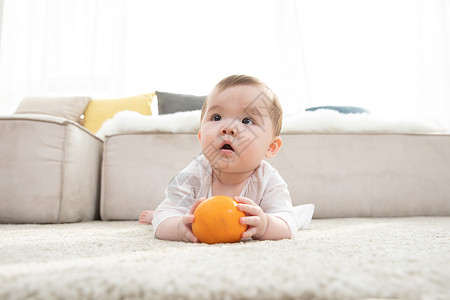 婴儿拿着橙子玩耍背景图片