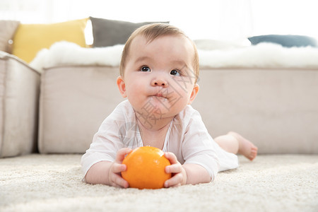 可爱小橙子婴儿拿着橙子玩耍背景