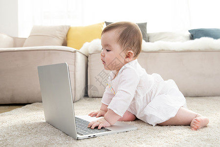 婴儿看着笔记本电脑背景图片