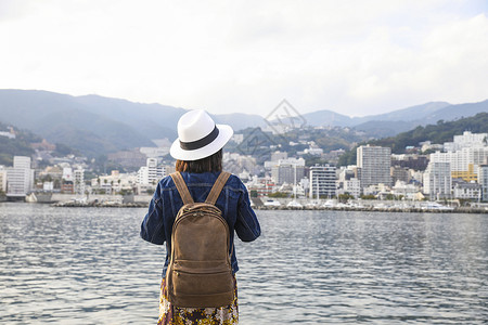 热海站在河边看风景的女人背影背景