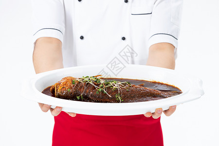 中国菜品厨师手捧红烧鱼菜品特写背景