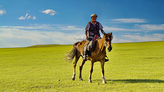 策马蒙古族大叔在呼伦贝尔大草原骑马背景