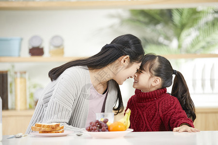 对视亲吻年轻妈妈和女儿吃早餐互动背景