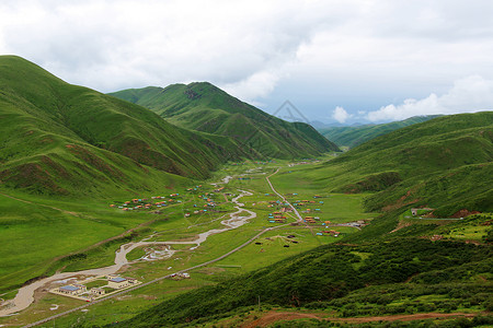 色达春季山顶总览群山蓝天白云绿色高山背景